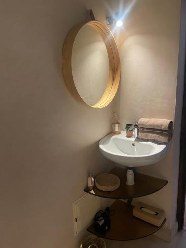ein Bad mit einem Waschbecken und einem Spiegel in der Unterkunft Maison La Chèvre in Essaouira