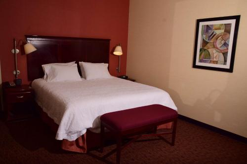 a bedroom with a large bed with a red wall at Hampton Inn Indiana in Indiana
