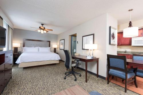 a hotel room with a bed and a desk and a computer at Homewood Suites by Hilton Indianapolis Northwest in Indianapolis