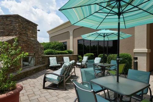 a patio with tables and chairs and an umbrella at Hampton Inn Bermuda Run / Advance in Bermuda Run