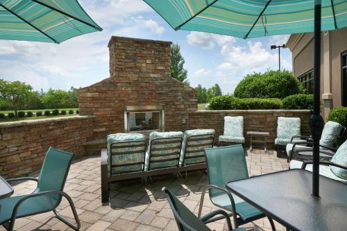 a patio with tables and chairs and a brick fireplace at Hampton Inn Bermuda Run / Advance in Bermuda Run