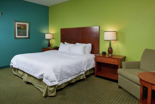 Habitación de hotel con cama y silla en Hampton Inn Bermuda Run / Advance, en Bermuda Run