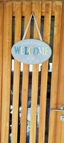 a welcome sign on top of a wooden fence at Šilarjeva huba Apartment in Bohinjska Bistrica