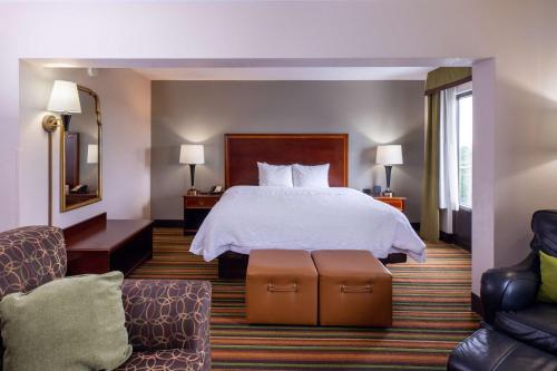 Habitación de hotel con 1 cama y 2 sillas en Hampton Inn Winston-Salem Hanes Mall en Winston-Salem