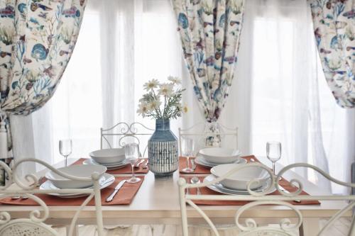 a dining room with a table with plates and glasses at Kasa 23 Cascais in Cascais