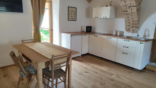 une cuisine avec une table en bois, une table et des chaises dans l'établissement Šilarjeva huba Apartment, à Bohinjska Bistrica