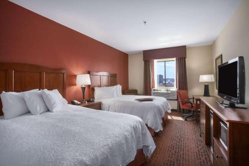 um quarto de hotel com duas camas e uma televisão de ecrã plano em Hampton Inn & Suites Williston em Williston