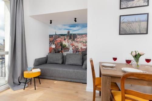 a living room with a couch and a table at Apartment Podwale Staromiejskie Gdańsk with Balcony by Renters in Gdańsk