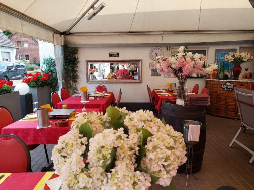 a restaurant with red tables and white flowers at Tapas Restaurante 2 in Viersen
