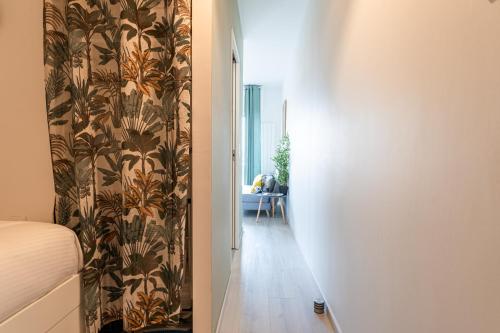 a hallway with a bed and a wall with a wallpaper at Piton des Neiges - Nid douillet terrasse vue port in Arcachon