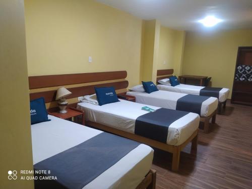 eine Gruppe von 4 Betten in einem Zimmer in der Unterkunft Hotel La Posada Real Arequipa in Arequipa