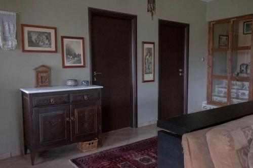 - une chambre avec un lit et une commode en bois dans l'établissement Leveniotis Villa, à Angelochórion