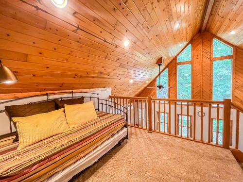 a bedroom with a bed in a wooden cabin at Modern Cabin with Hot Tub and Fire Pit in Swanton