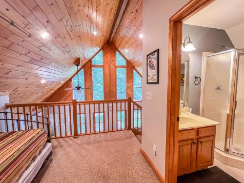 a log cabin bathroom with a sink and a shower at Modern Cabin with Hot Tub and Fire Pit in Swanton