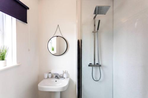 a white bathroom with a sink and a mirror at Plessey House Blyth by #ShortStaysAway in Cowpen