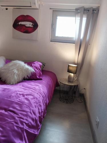 une chambre avec un lit violet et une fenêtre dans l'établissement CHARMANTE VILLA HELIOVILLAGE CAMP NATURISTE, au Cap d'Agde