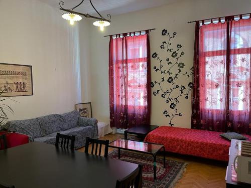 a living room with a couch and red curtains at Anna 2 bedrooms 2 bathrooms 6 bikes in Budapest