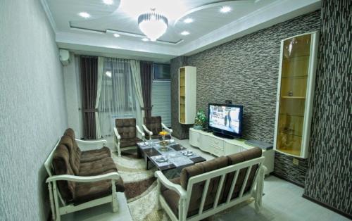 a living room with a couch and a tv at Квартира с хорошей энергетикой in Dushanbe