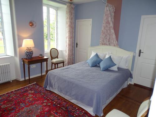 a bedroom with a bed and a table and a window at Manoir Saint Martin in Percy