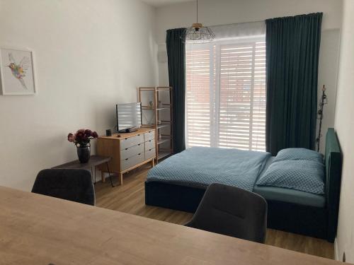 ニトラにあるModerný apartmán A408 v centre NR, parkovanie v ceneのベッドと机と窓のある寝室