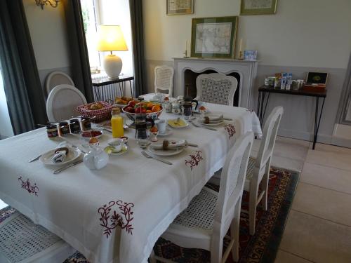 Una mesa con un mantel blanco con comida encima. en Manoir Saint Martin Chambres d'hôtes, en Percy