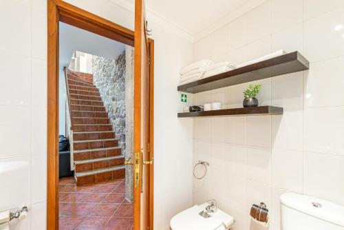 a bathroom with a toilet and a staircase at Sé Apartamentos - Casa da Sé in Braga