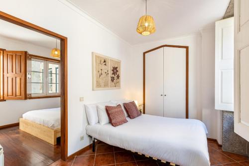 a bedroom with a bed and a mirror at Casa da Sé Historic next to Braga Cathedral by Sé Apartamentos in Braga