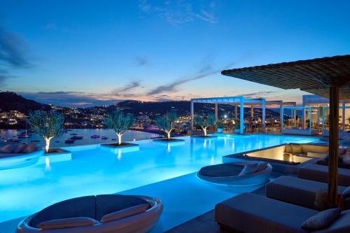 a large swimming pool with a view at night at Once in Mykonos - Designed for Adults in Ornos