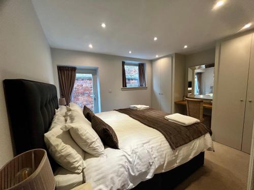 a bedroom with a large bed and a bathroom at Tanyard Barn - North Yorkshire in York