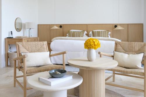 a room with two chairs and a table with a bed at Le Couvent des Minimes, un Hôtel & Spa L'Occitane en Provence in Mane