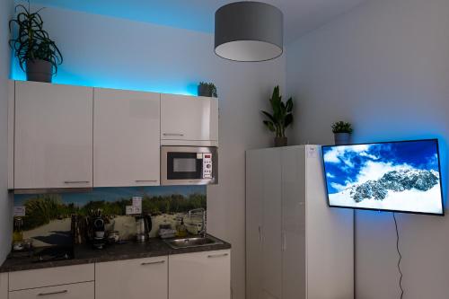 a kitchen with a tv hanging on the wall at Cozy apartment in city center in Prague