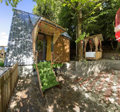 a wooden outhouse with a green seat in a yard at Forest House in Dandalo