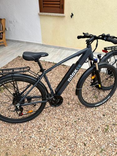 a black bike parked in front of a building at Molti Mari B&B Resort in Olbia