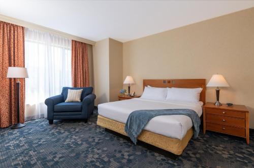 a hotel room with a bed and a chair at Wellsworth Hotel in Southbridge