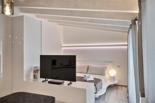 a living room with a bed and a flat screen tv at Casa Massima Suites & SPA in Casamassima