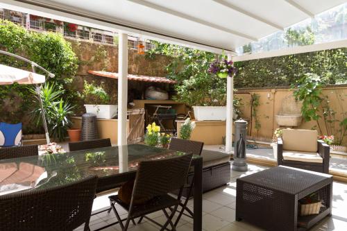 a patio with a glass table and chairs at Vacanze Romane con giardino in Rome