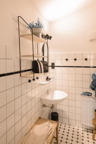 a bathroom with a sink and a tiled wall at Mamooi Julianadorp in Julianadorp