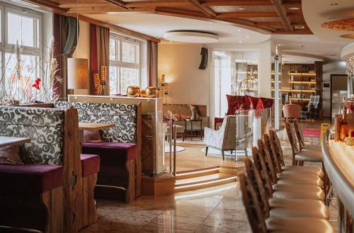 a restaurant with a bar with tables and chairs at Hotel Das Rübezahl in Schwangau
