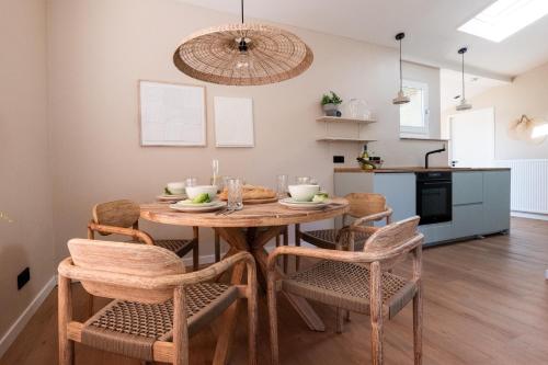 een keuken en eetkamer met een houten tafel en stoelen bij Mamooi Julianadorp in Julianadorp