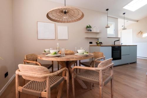 a kitchen and dining room with a wooden table and chairs at Mamooi Julianadorp in Julianadorp