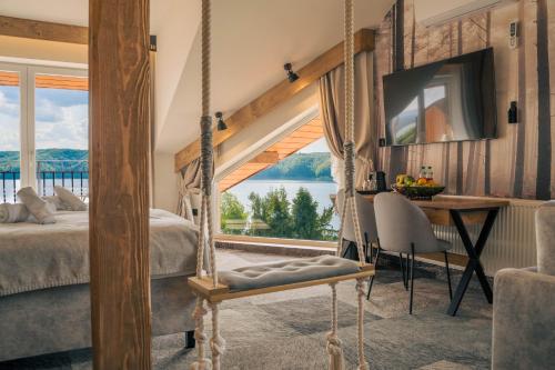 een slaapkamer met een bed, een bureau en een raam bij Sztygarka Hetmańska Resort Solina in Solina