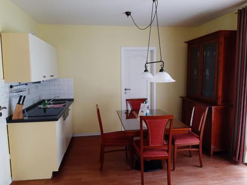 cocina y comedor con mesa y sillas en Residenz Lausitz - Apartments für Urlaub mit Hund, en Graal-Müritz