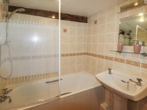 een badkamer met een bad, een wastafel en een douche bij Y Bwthyn in Betws-y-coed