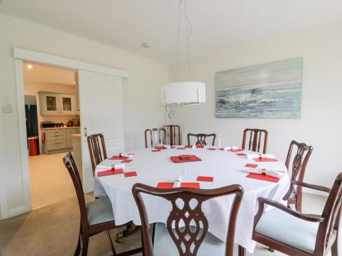 a dining room with a white table and chairs at Knockendoch in Dumfries