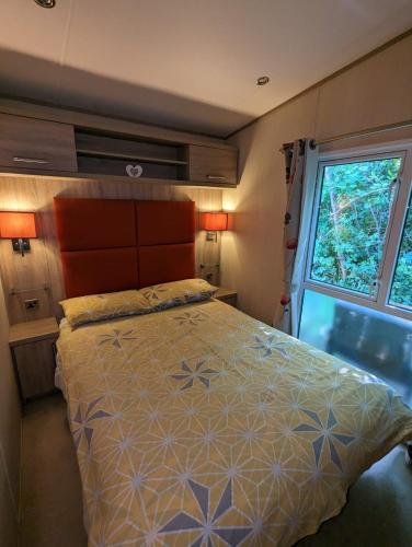 um quarto com uma cama e uma janela em Littlesea Caravan on a Fabulous elevated position Haven Weymouth em Weymouth