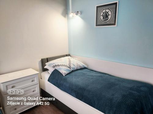 ヤスタルニャにあるPokoje u Rybakaの小さなベッドルーム(ベッド1台、ナイトスタンド付)