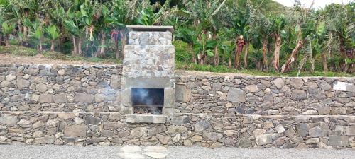 a stone wall with a fire place in it at Fazenda Apartments - Apartment 2 in Lajes das Flores