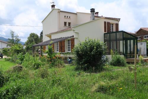 uma casa branca com janelas de vidro e um quintal em No.5 em Saint-Girons