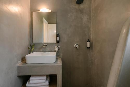 uma casa de banho com um lavatório e um espelho em Theros Retreat em Spartià
