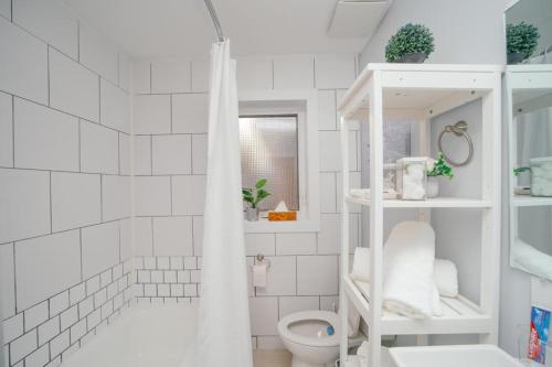 a white bathroom with a toilet and a shower at Cozy 3 Bedroom Contemporary Home With Free Parking in Edmonton